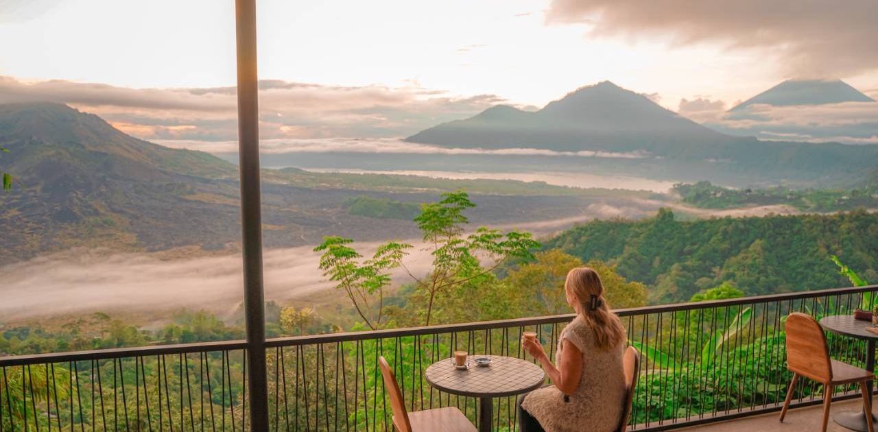 Girl drinking coffee with a view of Mt Batur Volcano Bali