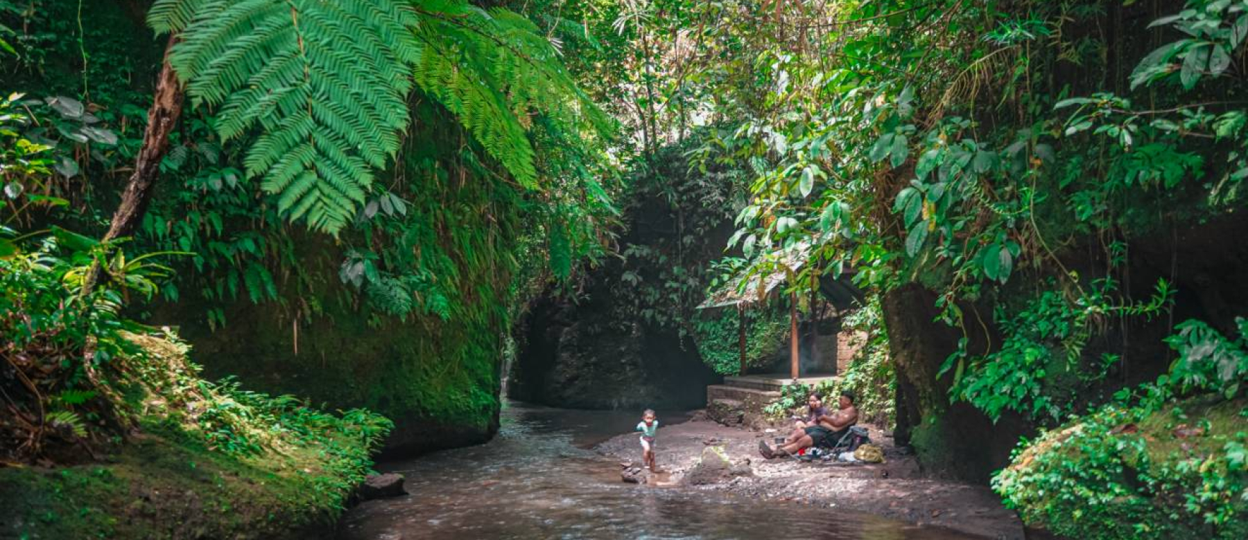 Family relaxing near river and waterfall in Ubud Bali